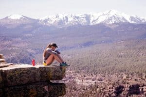 woman sitting on a rock over looking a canyon