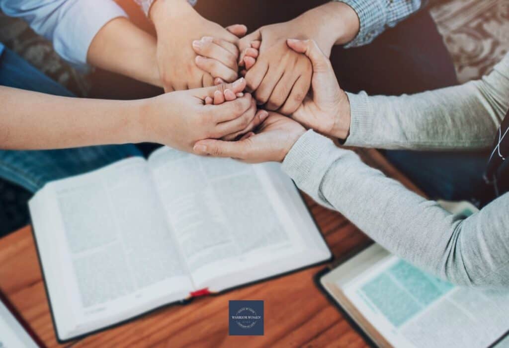 mother reading Bible and holding hands with her children