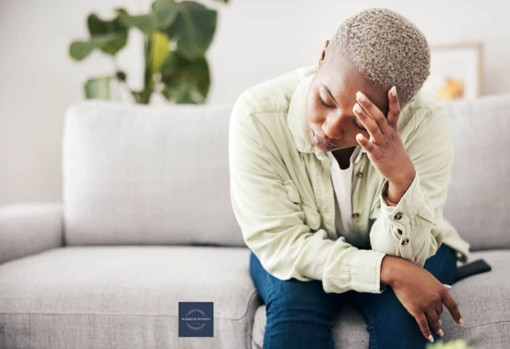 woman sitting on couch with head in hand