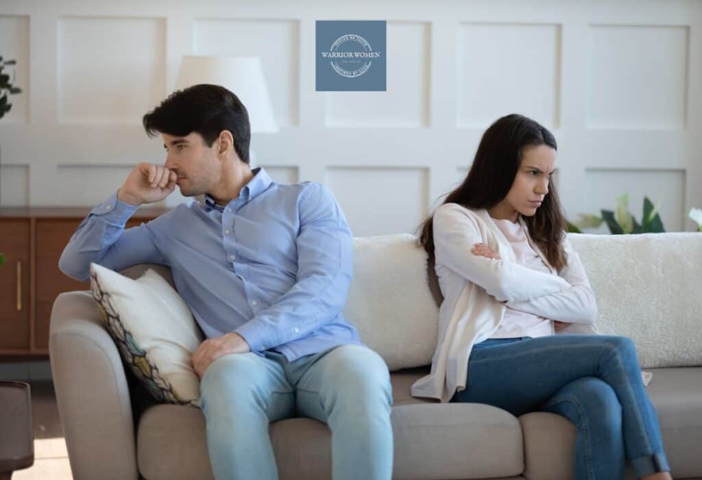 husband and wife sitting on couch with backs facing each other