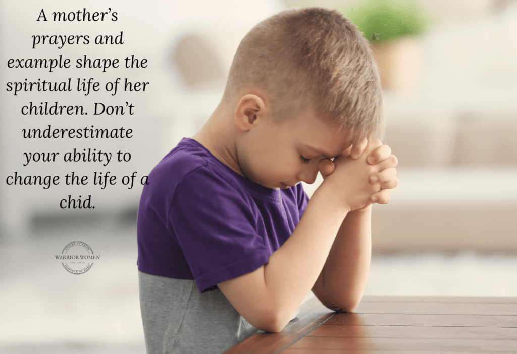 little boy with elbows on table praying