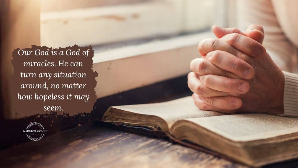 pray for prodigals woman's hands clasped together on and open Bible by a window